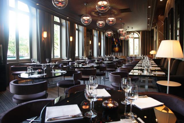 La salle du restaurant de laquelle on peut admirer l'arc de triomphe compte 110 places assises.