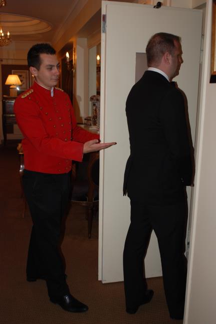 Pantalon noir sur veste rouge brodée à col Mao, Benoît Paty est liftier au restaurant étoilé Chez Lasserre