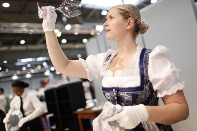 La candidate Autrichienne, ici habillée d'une longue robe vintage, typique de son pays, est ici en mise en place (vérification et propreté des couverts et verres) de sa table gastronomique.