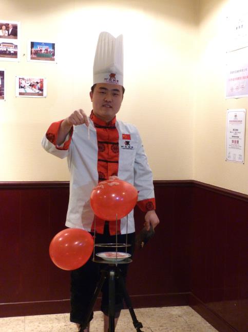 Zhao Yao, le Chef du restaurant A WU à Toulouse, en pleine démonstration de découpe de viande sur un ballon.
