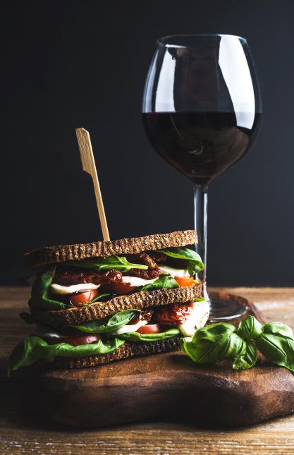 Un sandwich italien au basilic, avec un verre de vin rouge.