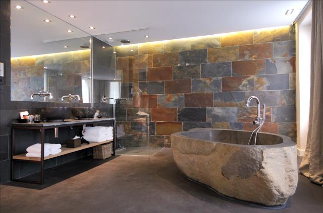 La salle de bains d'une des suites du Hidden bis, avec sa baignoire réalisée dans une pierre taillée.
