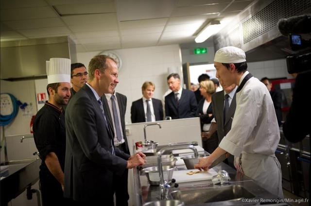Le ministre Guillaume Garot échange avec un élève de terminale bac professionnelle cuisine sous la responsabilité de M. Pons.