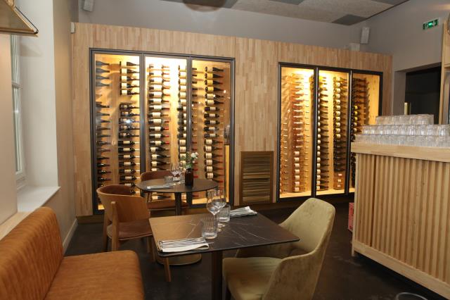 Dans l'une des salles du restaurant, une cave vitrée met en valeur les vins régionaux.