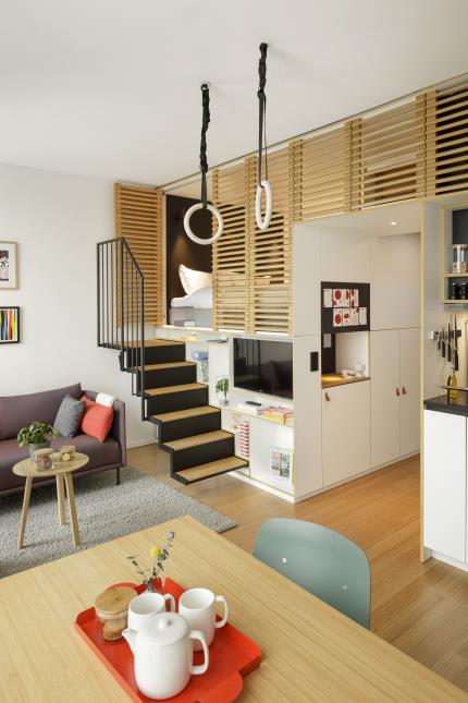 Un loft de Zoku Paris. La table à manger est au centre de la pièce et le lit est dissimulé derrière des claustras.