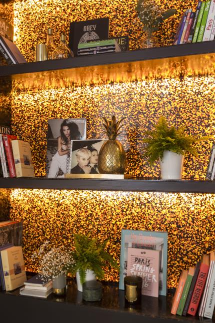 Une bibliothèque en acétate orangé, pour abriter des guides sur Paris.