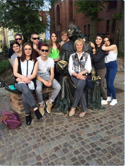 Le groupe d'élèves et leur professeur de restaurant Madame Hérault-Carteron devant la statue de Nicolas Copernic à Olsztyn
