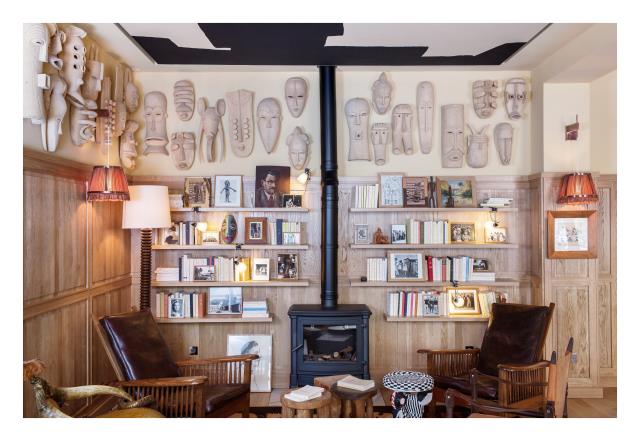 Dans le salon ont été placés des masques africains, des peintures, et une bibliothèque alimentée par des livres des Éditions Gallimard, coup de coeur de la propriétaire.