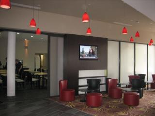 Lobby intérieur à la décoration aux  couleurs « pop », pistache et prune.