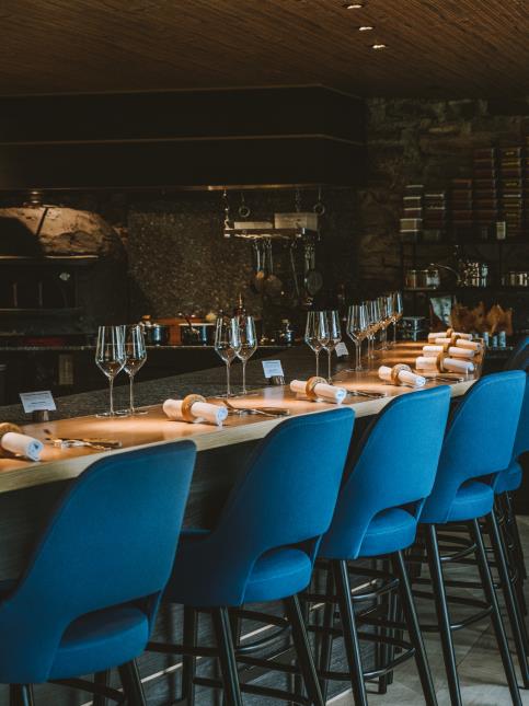 À la Villa Pinewood, 14 convives s'installent le long d'un comptoir ouvert sur la cuisine et le cellier.