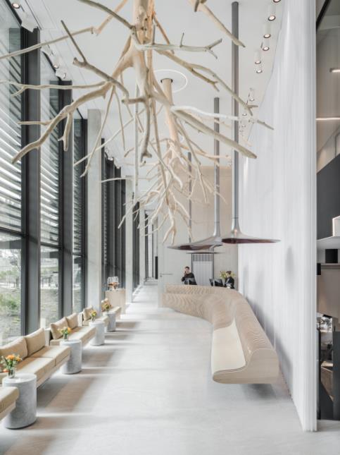 Le hall marie arbres suspendus, lampes champignons et banque d'accueil en forme d'ammonite déroulée.