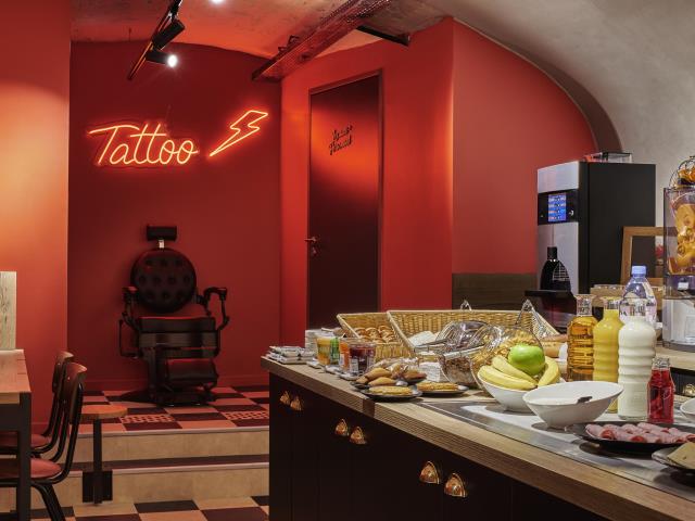 Un siège de tatoueur dans la salle des petits déjeuners de l'Ibis Styles Paris Gare de l'Est Magenta..