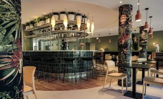 Le bar central et une partie du restaurant, dont la décoration est axée sur le végétal'