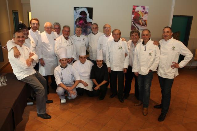 Les membres du jury et les apprentis sur le podium avec la gagnante, Elisa Leriche, toute de noir vêtue.