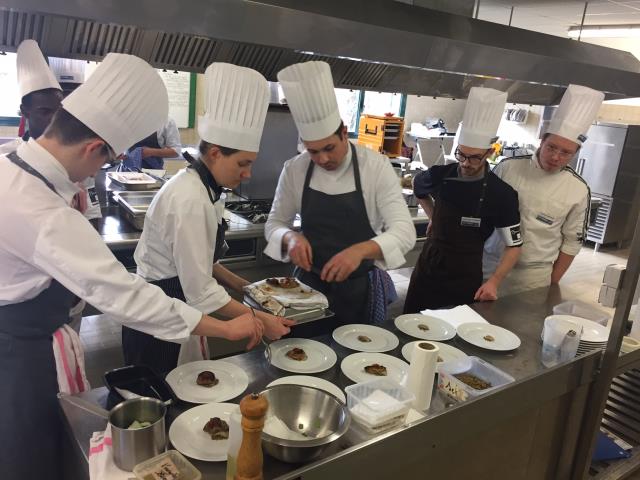 Dan officiant dans la cuisine pédagogique de l'IFPP, secondé par une brigade d'apprentis cuisiniers, boulangers, pâtissiers et serveurs pour préparer un menu d'exception pour 55 convives.