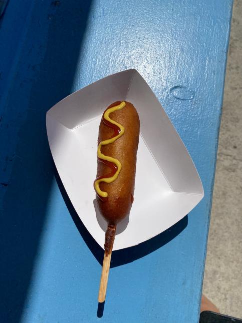 Un corn dog accompagné de moutarde et ketchup. 