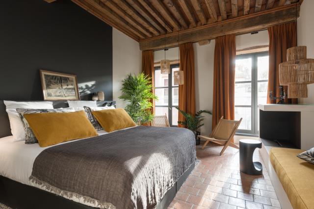 La suite Ocre est inspirée des années « Cadaquès » 60-70 avec des tons colorés (jaune moutarde et terracotta), des matériaux bruts, des notes végétales ou encore un parement mural vintage.
