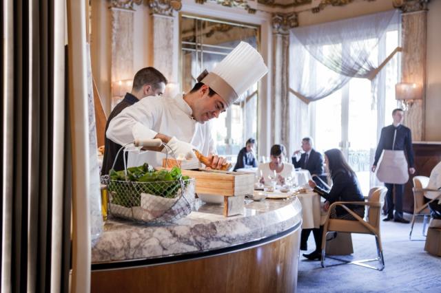 Au moment du service du fromage, un cuisinier y assaisonne les salades.