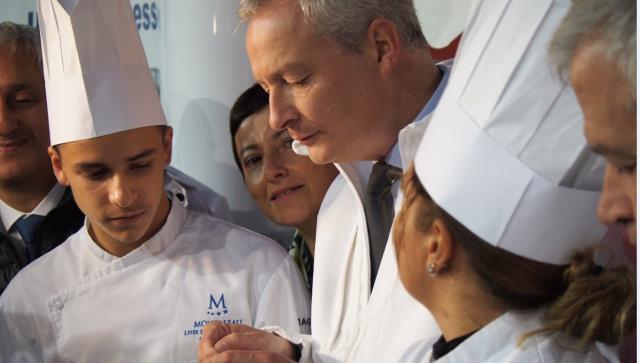 Bruno Le Maire observant attentivement le travail des jeunes du lycée Montaleau