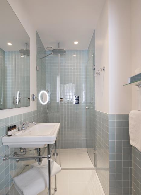 Les salles de bain, leur robinetterie argentée et les carreaux de verre surfent sur la tendance rétro.