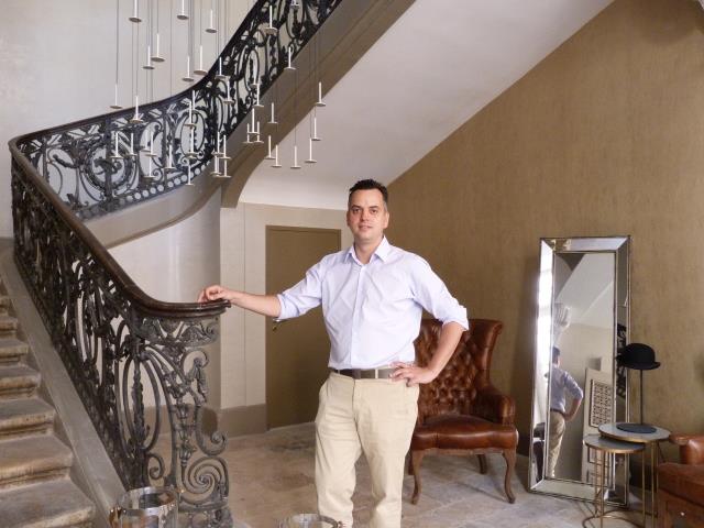 Hadrien Pujol directeur général du groupe Cité Hôtels devant l'escalier central de la Cour des Consuls Gallery Toulouse