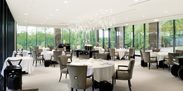 La salle du restaurant, conçu par Mario Botta, s'ouvre sur le parc de six hectares qui entoure la Villa René Lalique.