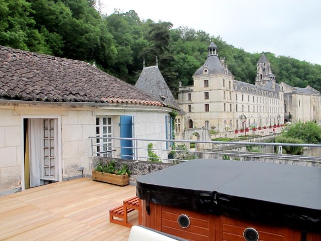Vue sur l'abbaye Saint Pierre et le plus ancien clocher de France (XIe) depuis la terrasse privative avec jacuzzi de la chambre  «  caractère »