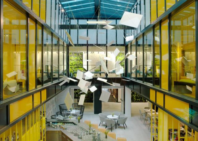 D'emblée, le bar - station centrale et baignée de lumière sous la verrière - donne le ton. Ses carreaux de verres jaunes jouent les filtres diffuseurs dans cette ambiance à l'inspiration nordique, tandis que la lumière naturelle des verres incolores inond
