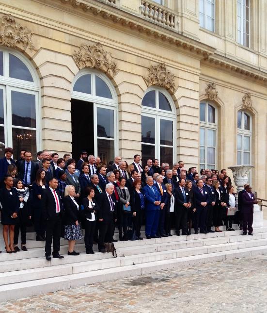 Les participants au 23e congrès de l'Amforht sur le parvis de l'Hôtel de Lassay, résidence du président de l'Assemblée nationale à Paris.