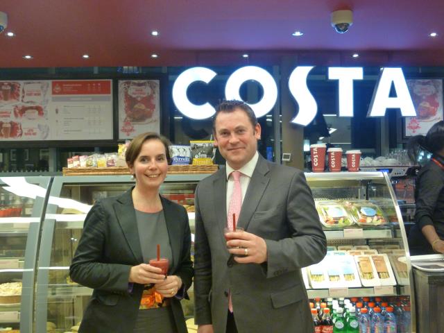 Cathy Dufour, directrice marketing et développement d'Elior concessions, et Steve Holloway, directeur du développement international de Costa Coffee, devant le comptoir du premier point de vente situé à Paris-Gare de Lyon (hall 2).