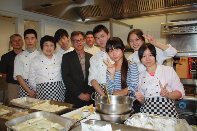 Les étudiants chinois de la Shanghai Trade School dans la cuisine du restaurant d'application Vercors avec Thomas Viron, directeur de l'IMT(au centre), leur traductrice (haut rayé bleu), Christophe Etaix, responsable du secteur Restauration (à gauche) et 