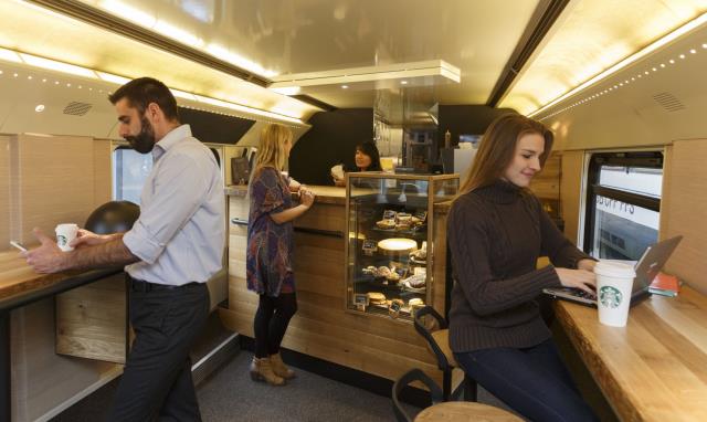 A l'entrée, les baristas servent les passagers à l'arrière d'un bar en bois arrondi muni d'une petite boîte à pâtisserie.