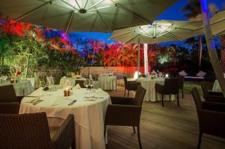 La salle du restaurant Bartolomeo, située au milieu des jardins tropicaux du Guanahani & Spa.