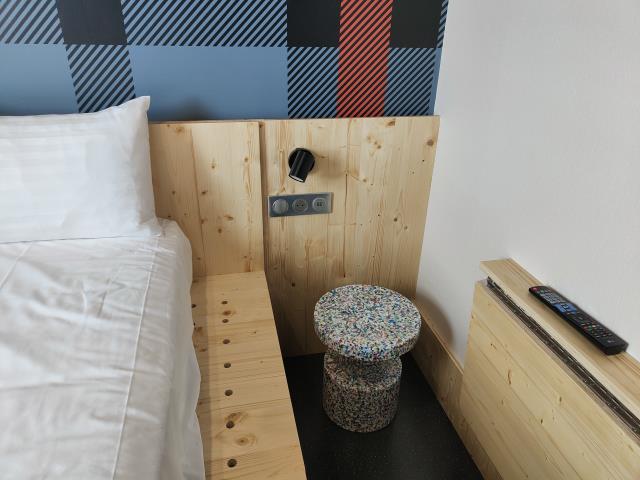 Le nouveau design des chambres intègre du bois et des matériaux recyclés, comme le tabouret, composé de plastique recyclé.