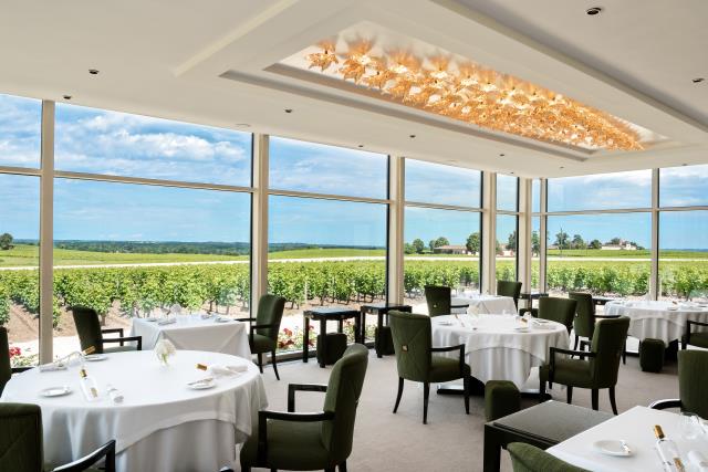 Une partie du restaurant se situe dans une verrière, donnant sur les vignes du domaine. Le plafond est orné de feuilles Champs-Elysées, en cristal lustré or.