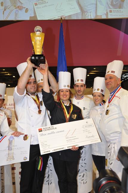 Gaëtan Fiard  et Johanna Le Pape brandissent le trophée sous le regard de leurs coachs.