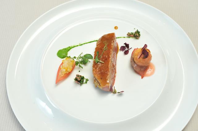 Magret de canette de barbarie mariné aux épices et à l'orange, oignons farcis de ses abats, chutney de fruits et cromesquis de patates douces.