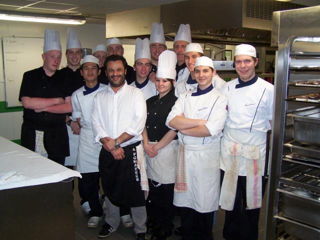 Gérald Garcia entouré des élèves et de leur professeur de cuisine.