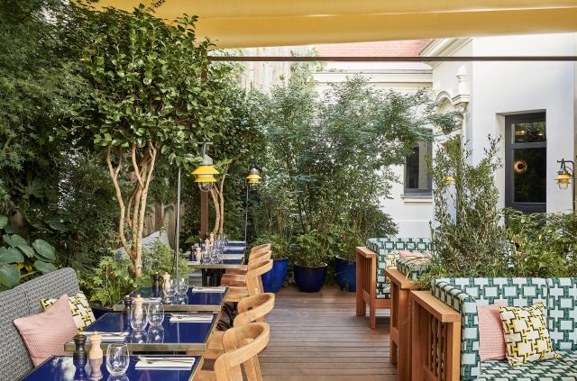 Les clients peuvent déjeuner dans la cour arborée de l'hôtel Ballu, à Paris.