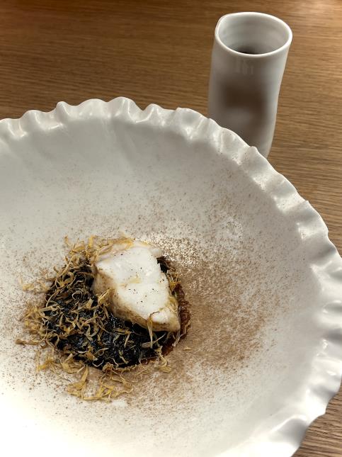 Silure de Loire ikejime fumé au foin, condiment à l’ail noir, jus d’arêtes à l’ail noir et fleurs de souci