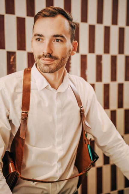 Maxence Courboulès, responsable de salle du restaurant Table, à Blois, avec son « holster de service », créé sur mesure.