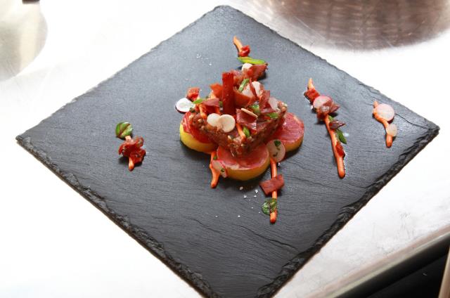 Tartare de veau au jambon, huile d'agrumes, pommes fondantes, coppa, mascarpone tomaté et allumettes de jambon Aoste réalisé par Teddy Odorico.