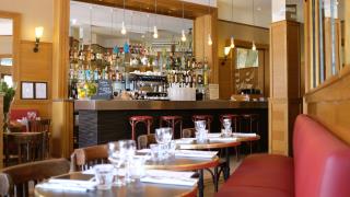 Banquettes rouges et tables bistrot au Petit Saint Louis