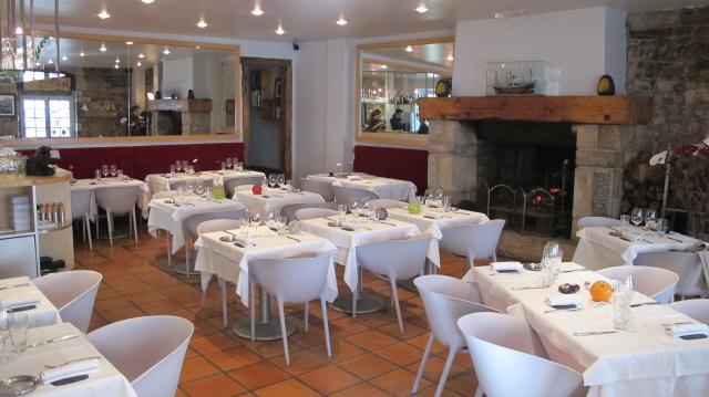 : murs en pierres apparentes, cheminée, et mobilier contemporain accueillent sur nappes blanches 45 couverts dans cette maison du XVIII