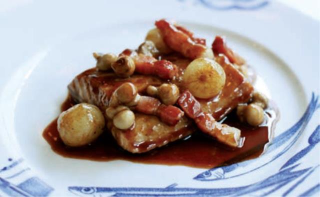 Pavé d'esturgeon poché dans une sauce à base de vin rouge avec des petits oignons, lardons fumés, champignons de Paris.