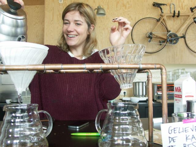 Annelies Browaeys prépare ses grans crus de café en verion 'slow café', devant les clients, avec un vélo comme décor.