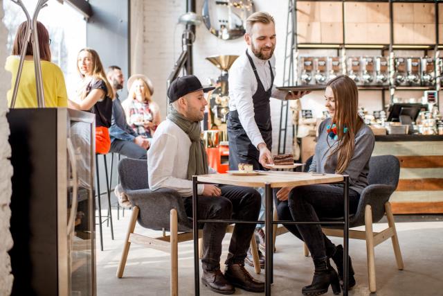 Serveur apportant leurs plats aux clients