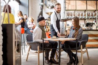 Serveur apportant leurs plats aux clients