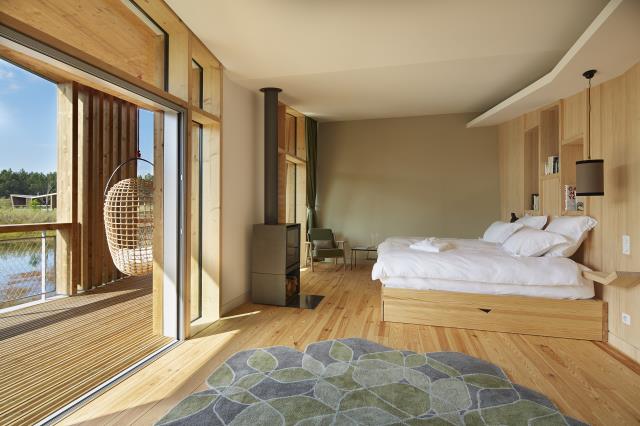 Des chambres à la fois luxueuses et épurées : poêle à bois, lit de 2m x 2m dans un cadre chaleureux et lumineux