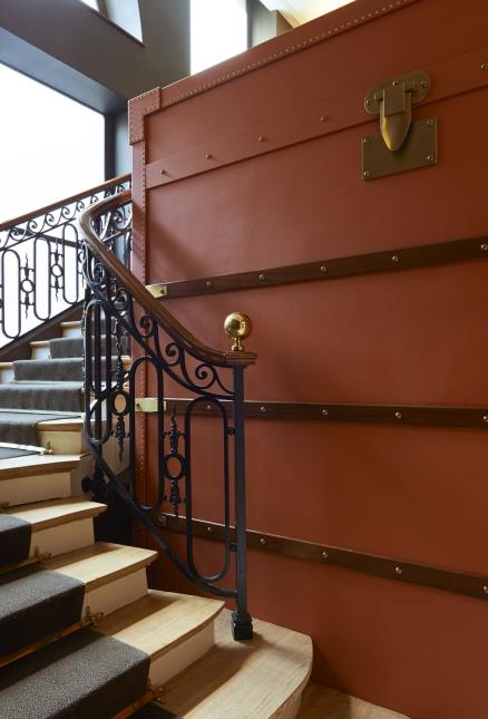 La bagagerie, adossée à un escalier du XVIIIe siècle, est installée dans une malle Louis Vuitton géante.